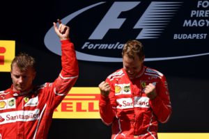Winner Ferrari's German driver Sebastian Vettel (R) and second-placed Ferrari's Finnish driver Kimi Raikkonen celebrate on the podium after the Formula One Hungarian Grand Prix at the Hungaroring racing circuit in Budapest on July 30, 2017. / AFP PHOTO / ANDREJ ISAKOVIC