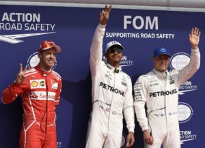 Mercedes' British driver Lewis Hamilton (C) celebrates winning the pole position next to second placed Ferrari's German driver Sebastian Vettel (L) and third placed Mercedes' Finnish driver Valtteri Bottas after the qualifying session at the Spa-Francorchamps circuit in Spa on August 26, 2017 ahead of the Belgian Formula One Grand Prix. / AFP PHOTO / JOHN THYS