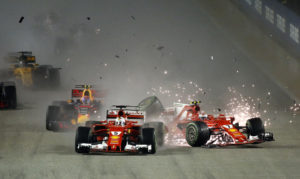 Ferrari driver Kimi Raikkonen, right, of Finland collides with teammate Sebastian Vettel of Germany at the start of the Singapore Formula One Grand Prix on the Marina Bay City Circuit Singapore, Sunday, Sept. 17, 2017. (AP Photo/Yong Teck Lim)