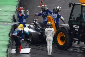 Mercedes' British driver Lewis Hamilton (in white) looks as his car is removed from the racetrack after crashing during the Brazilian Formula One Grand Prix Q1 qualifying session at the Interlagos circuit in Sao Paulo, Brazil, on November 11, 2017. / AFP PHOTO / Nelson ALMEIDA