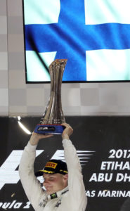 Mercedes' Finnish driver Valtteri Bottas celebrates on the podium at the end of the Abu Dhabi Formula One Grand Prix at the Yas Marina circuit on November 26, 2017. Bottas won the season-ending Abu Dhabi Grand Prix, finishing ahead of world champion Lewis Hamilton with Sebastian Vettel taking third. / AFP PHOTO / KARIM SAHIB