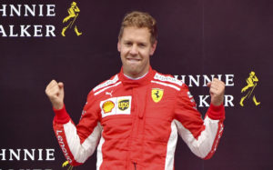 Ferrari driver Sebastian Vettel of Germany jubilates on the podium after winning the Belgian Formula One Grand Prix in Spa-Francorchamps, Belgium, Sunday, Aug. 26, 2018. Mercedes driver Lewis Hamilton of Britain placed second and Red Bull driver Max Verstappen of the Netherlands placed third. (AP Photo/Geert Vanden Wijngaert)