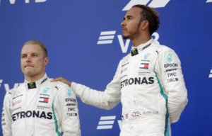 Second placed Mercedes driver Valtteri Bottas of Finland, left, and winner Mercedes driver Lewis Hamilton of Britain listen to the anthems after the Russian Formula One Grand Prix at the Sochi Autodrom circuit in Sochi, Russia, Sunday, Sept. 30, 2018.(AP Photo/Sergei Grits)