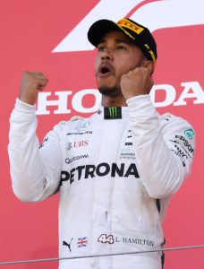 Mercedes' British driver Lewis Hamilton celebrates on the podium following his victory in the Formula One Japanese Grand Prix at Suzuka on October 7, 2018. (Photo by Toshifumi KITAMURA / AFP)