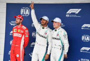 Mercedes' British driver Lewis Hamilton (C) celebrates after taking the pole position, next to Ferrari's German driver Sebastian Vettel (L) who took the second place and Mercedes' Finnish driver Valtteri Bottas (R) who took the third place, after the qualifying session for the F1 Brazil Grand Prix at the Interlagos racetrack in Sao Paulo, Brazil on November 10, 2018. (Photo by Nelson Almeida / AFP)
