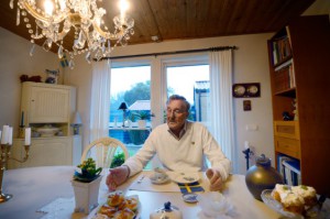 Hemma i radhusvillan bjuder Svenny Håkansson på tårta och kaffe. – Vi måste kunna umgås, även om vi har olika åsikter, säger han. (Foto: Stefan Mattsson)