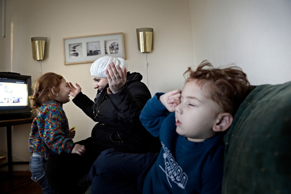Dima Alkurdi busar med dottern Hala. Bredvid sitter sonen Yazeh, 3, med feber. Foto: Stefan Mattsson.