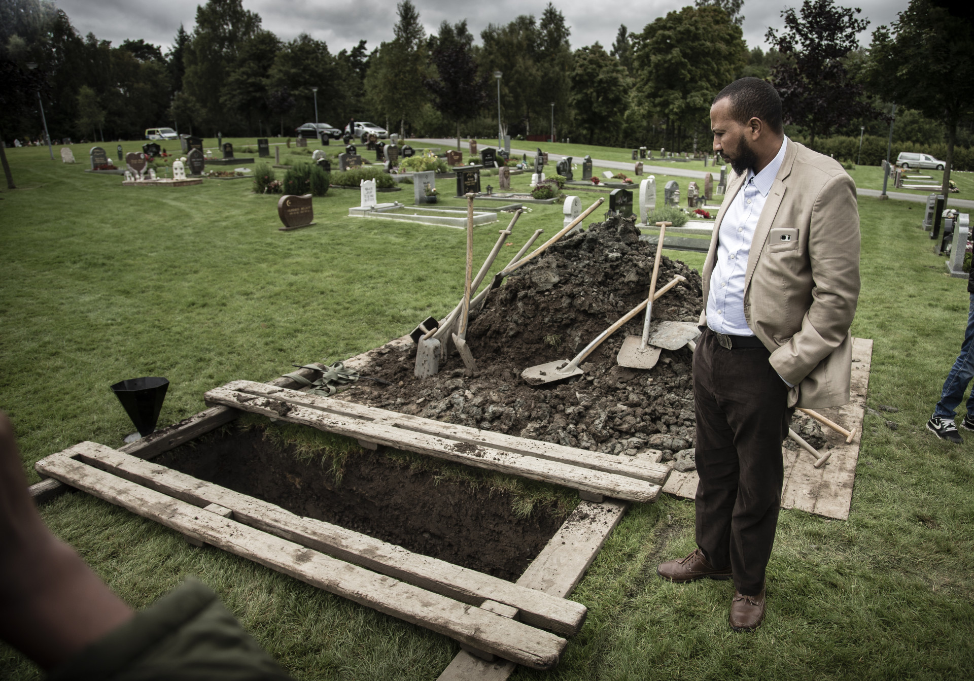 foto : anders deros : dokument om biskopsgrden. 8-rige yuusuf ddades nr en handgranat kastades in i en lgenhet p dimvdersgatan i biskopsgrden. yuusuf som kom frn england begravdes i gteborg. hans pappa abdiwahid warsame vid graven efter ceremonin. jordfstningen gde rum p fridhems kyrkogrd. text: peter kadhammar. foto: anders deros
