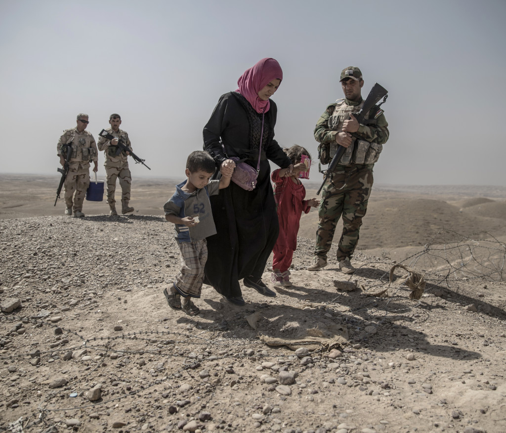 foto : magnus wennman : irak. fronten mot is. i bergen utanfr mosul har kurdiska styrkorna, persmerga sin frontlinje mot is. 12 mn, kvinnor och barn som lyckats fly frn en is kontrollerad by har tagit sig genom knen och skt skydd hos de kurdiska styrkorna. de frhrs och kontrolleras noga innan de frs vidare p et lasbilsflak mot ytterligare frhr och senare till flyktinglger.