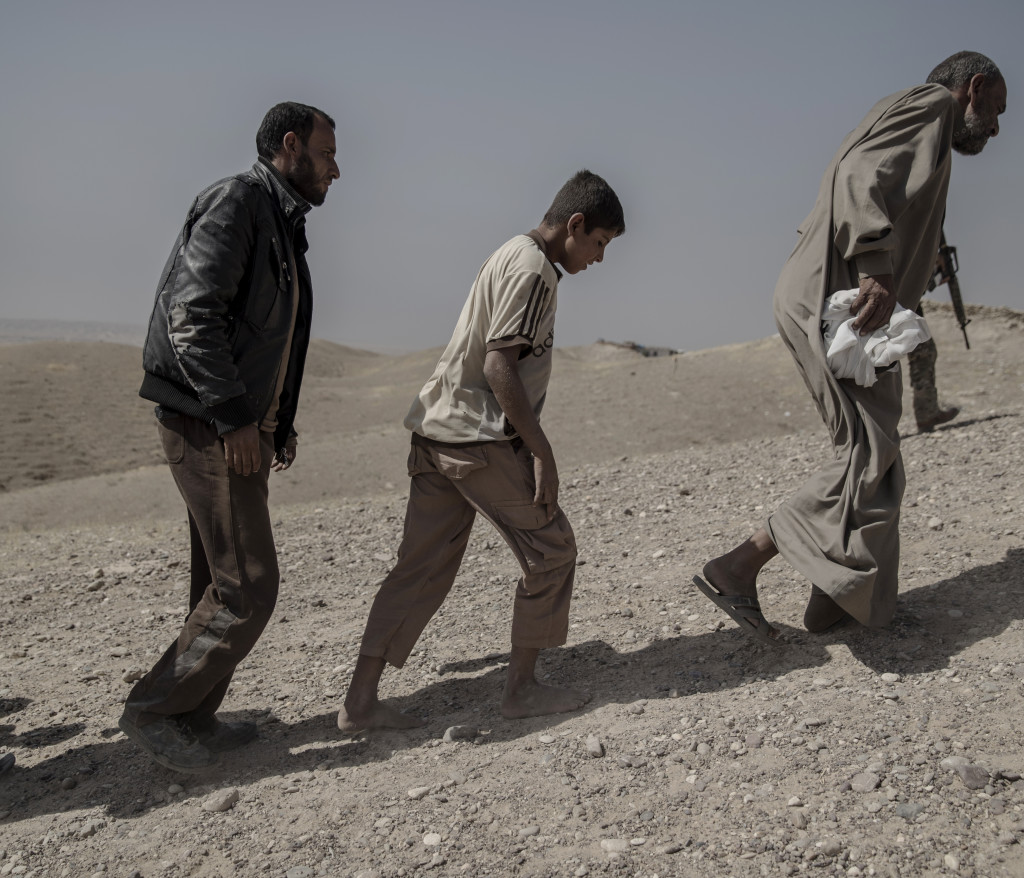 foto : magnus wennman : irak. fronten mot is. i bergen utanfr mosul har kurdiska styrkorna, persmerga sin frontlinje mot is. 12 mn, kvinnor och barn som lyckats fly frn en is kontrollerad by har tagit sig genom knen och skt skydd hos de kurdiska styrkorna. de frhrs och kontrolleras noga innan de frs vidare p et lasbilsflak mot ytterligare frhr och senare till flyktinglger.