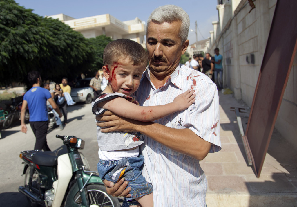 ap foto : khalil hamra : a syrian man carries an injured child to a field hospital after an air strike hit homes in the town of azaz on the outskirts of aleppo, syria, wednesday, aug. 15, 2012. (ap photo/khalil hamra) / scanpix code: 436 mideast syri automatarkiverad