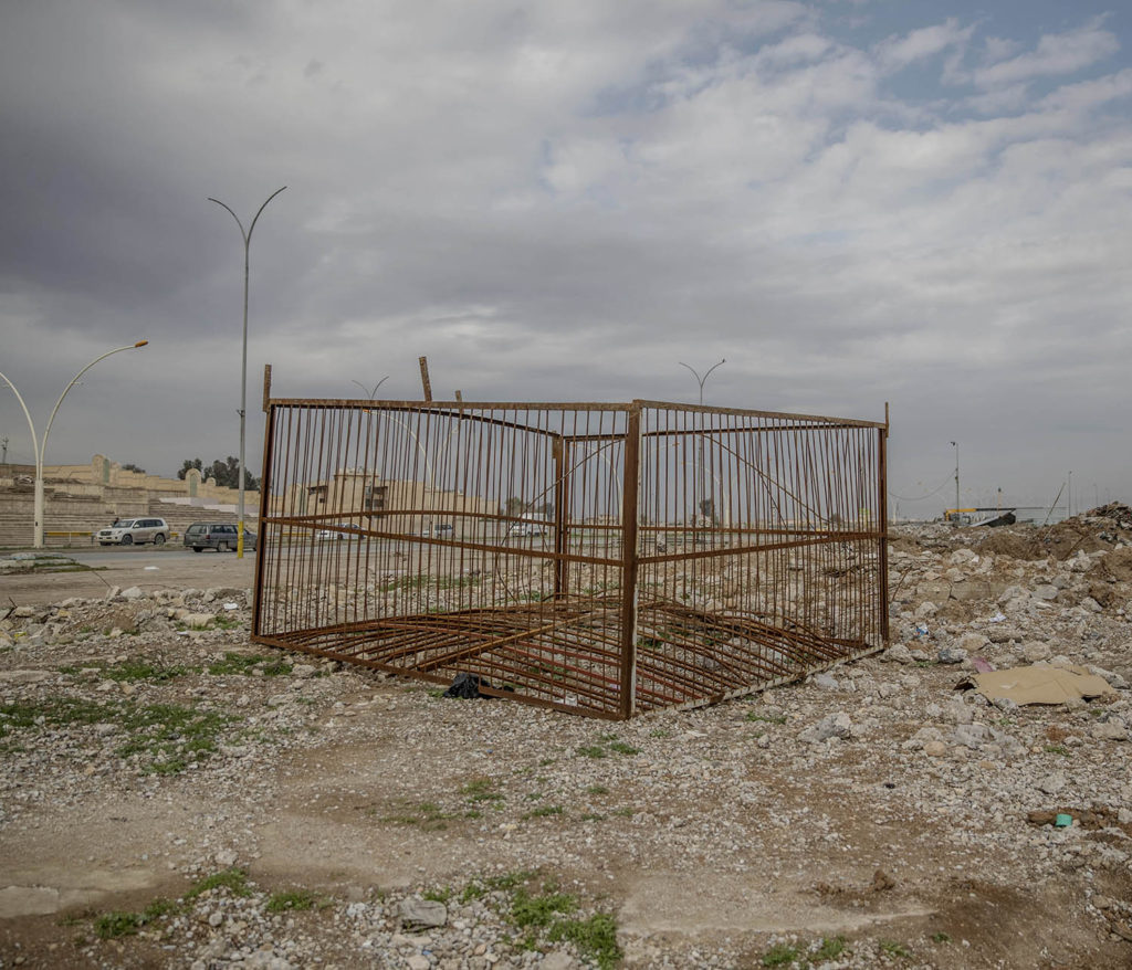 foto : magnus wennman : östra mosul, irak. adnan tahar visar platser där is avrättade människor i östra mosul. en stålbur står uppställd nedanför en stor läktare, där brukade is bränna eller skjuta människor som de ansåg gjort något fel.