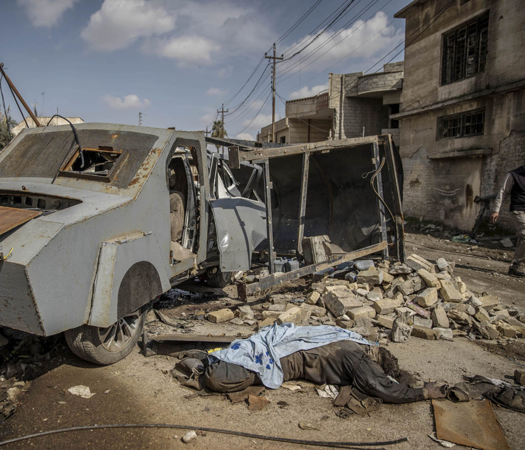 foto : magnus wennman : mosul, irak. en död is krigar ligger intill den bepansrade självmordsbilen som han körde. en stadsdel i västra mosul är totalförstörd efter hårda strider mellan is och irakiska styrkor. flyktingar strömmar ut från stadskärnan i takt med att irakiska armen befriar fler områden.