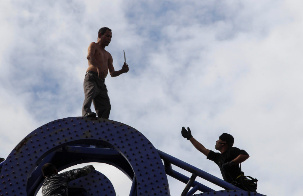 MANAGUA 2017-07-27
A special forces soldier tries to convince Julio Lopez, carrying a knife in his hand, not to jump off the "Tree of Life" metal sculpture to commit suicide, in Managua, Nicaragua July 27, 2017. REUTERS/Oswaldo Rivas TPX IMAGES OF THE DAY
Photo: / REUTERS / TT / kod 72000