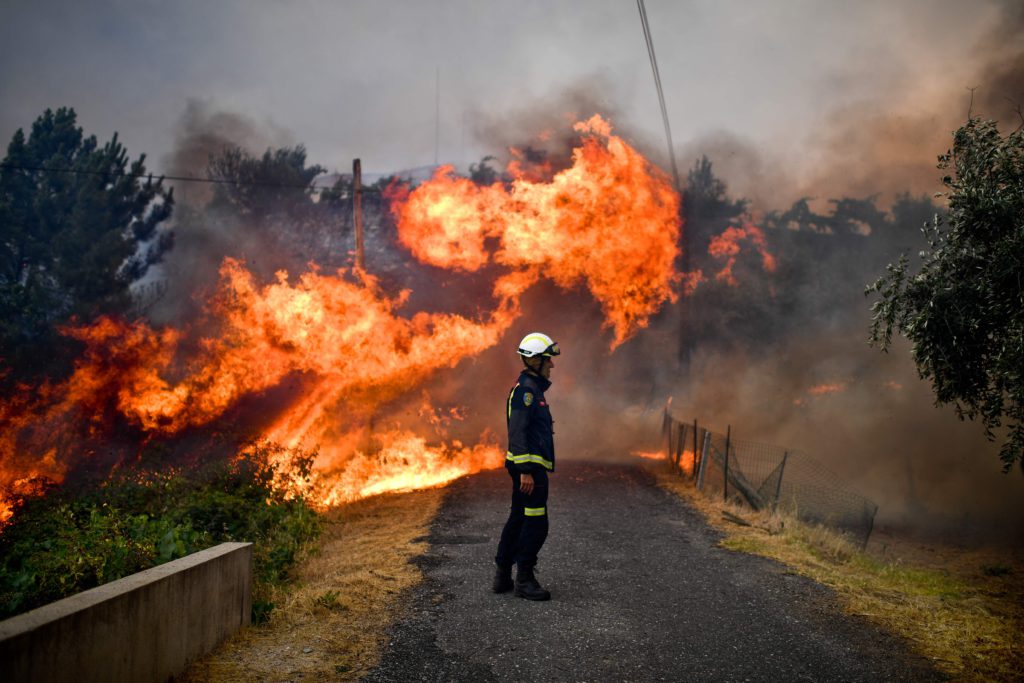 TOPSHOT - A firefighter stands in the middle of a road near flames blazing near the village of Sanguinheira, in Macao, central Portugal, on July 25, 2017. / AFP PHOTO / PATRICIA DE MELO MOREIRA / TT / kod 444