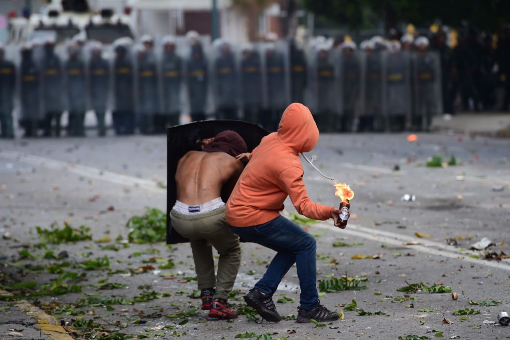 TOPSHOT - An anti-government activist prepares to throw a Molotov cocktail at members of the National Guard during a 48-hour general strike called by the opposition, in Caracas on July 26, 2017.
Venezuelans began blocking off deserted streets Wednesday as the opposition launched a 48-hour general strike aimed at thwarting embattled President Nicolas Maduro's controversial plans to rewrite the country's constitution. / AFP PHOTO / Ronaldo SCHEMIDT / TT / kod 444