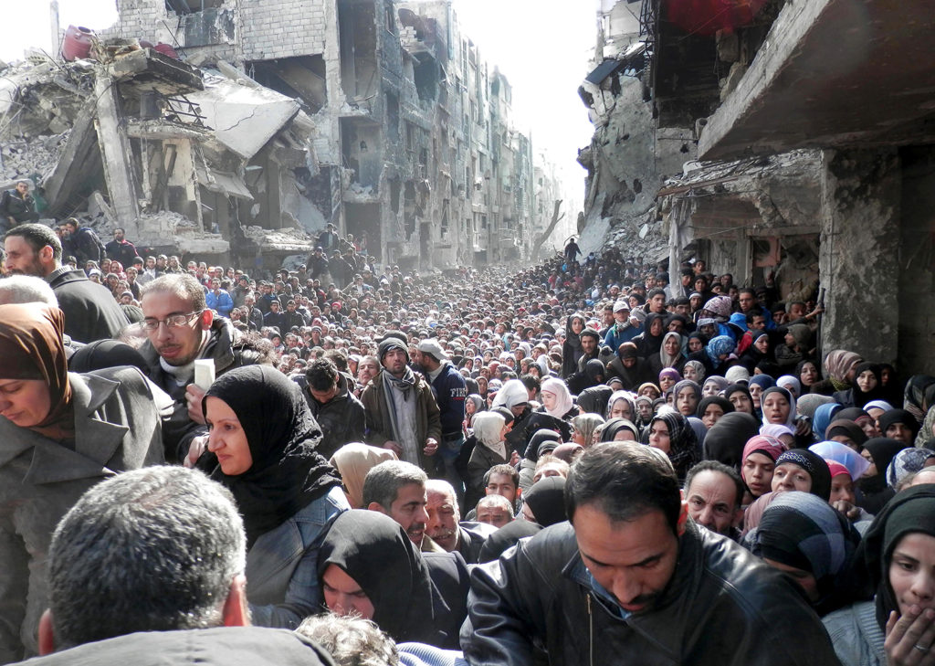 ap foto : uncredited : file - this file picture taken on jan. 31, 2014, and released by the united nations relief and works agency for palestine refugees (unrwa), shows residents of the besieged palestinian camp of yarmouk, queuing to receive food supplies, in damascus, syria. an international advocacy group accused the united nations of not being neutral in the syrian conflict in a trenchant report on wednesday, june 15, 2016, claiming the world body is prioritizing its relationship with the damascus government over delivering aid to civilians. (unrwa via ap, file) january 31, 2014, file photo ap provides access to this handout photo to be used solely to illustrate news reporting or commentary on the facts or events depicted in this image. this image may be used only for 14 days from the time of transmission; no arc mideast syri automatarkiverad