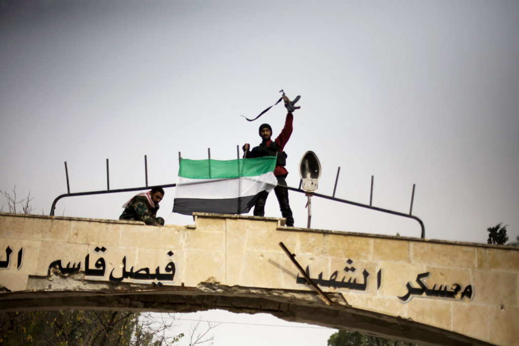 ap foto : manu brabo : free syrian army fighter puts up a fsa flag after heavy clashes with government forces at a military academy besieged by the rebels in tal sheer, syria, sunday, dec 16, 2012 (ap photo / manu brabo) / scanpix code: 436 mideast syri automatarkiverad