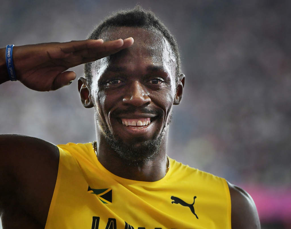friidrotts-vm 2017 i london. 100 m, herrar, kval. usain bolt, friidrottare jamaica löpare stannar upp i mixade zonen och gör honnör åt sportbladet, tävling action, gestikulerar, glad,